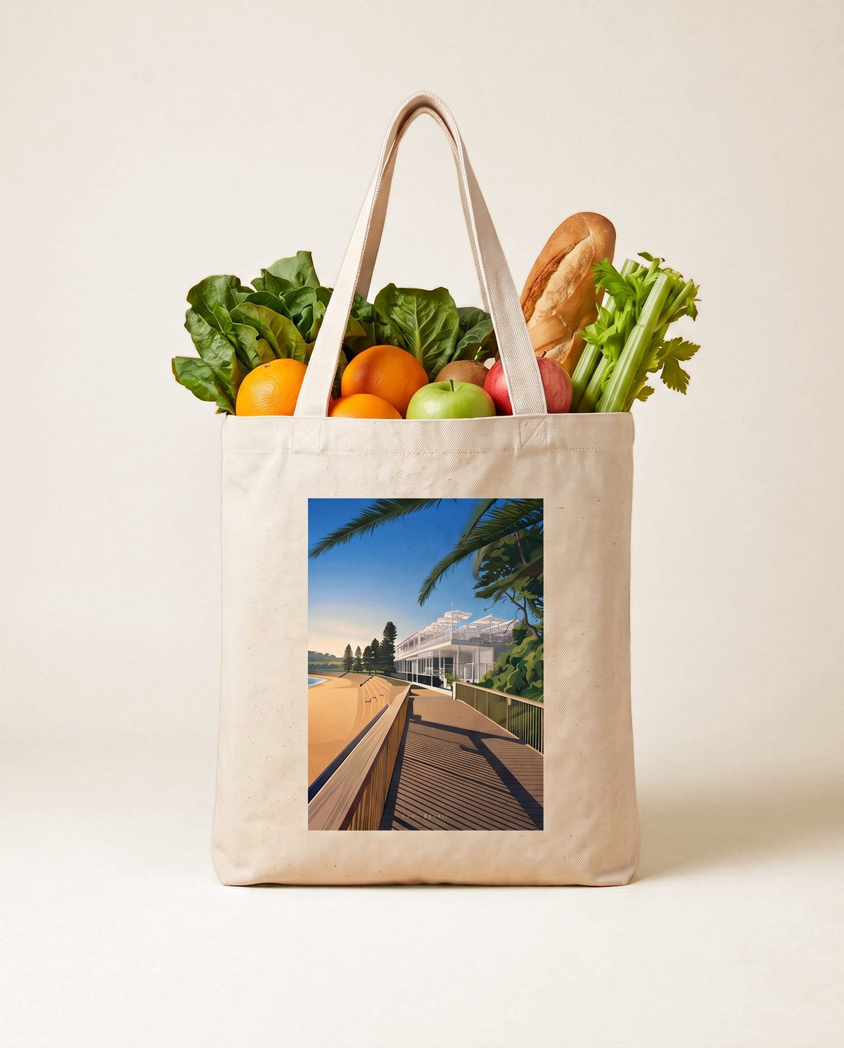 Coast & Compass Boardwalk Light tote bag packed with fresh groceries against a teal studio backdrop, cream cotton canvas printed with the Boardwalk Light artwork
