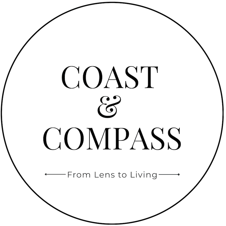 A circular black-and-white logo with the text 'COAST & COMPASS' and the tagline 'From Lens to Living' centered inside a thin black circle on a white background.