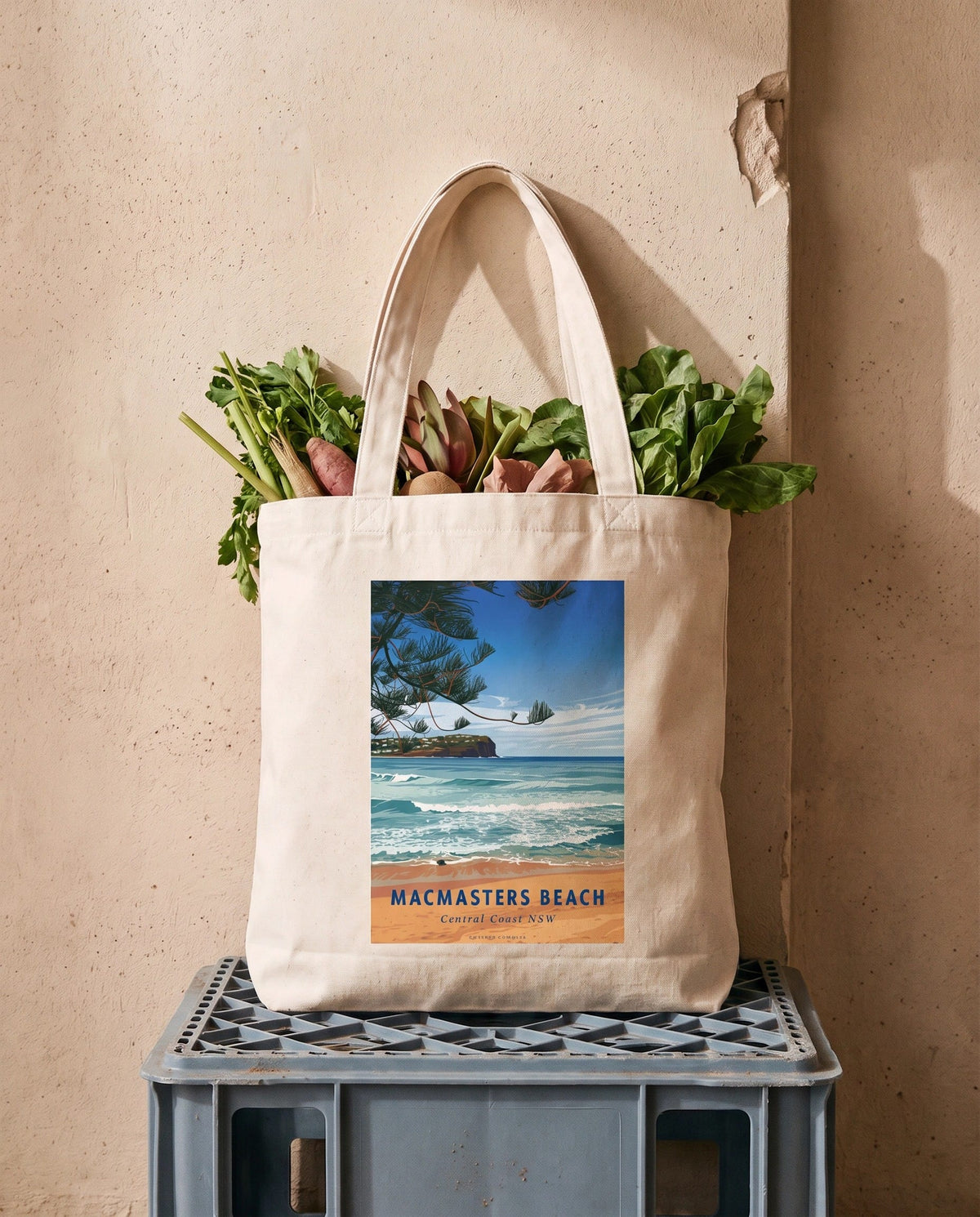 Coast & Compass Macmasters Beach tote bag packed with leafy greens and vegetables, resting on a grey crate against a warm plaster wall