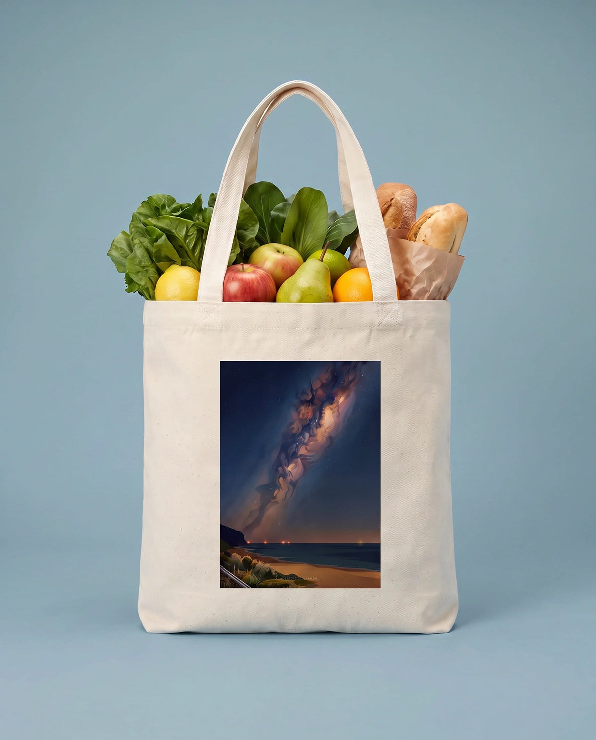 Coast & Compass Midnight Bloom tote bag packed with fresh groceries against a powder blue studio backdrop, cream cotton canvas printed with the Midnight Bloom artwork