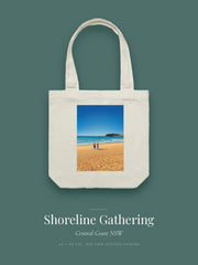 Shoreline Gathering artwork printed on a cream cotton canvas tote bag — three figures pausing for a chat on an empty beach