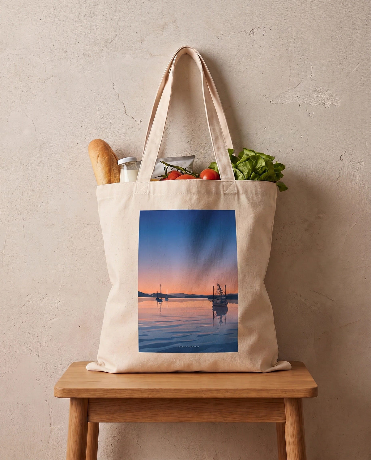 Coast & Compass Still Waters tote bag packed with fresh groceries, cream cotton canvas printed with the Still Waters artwork