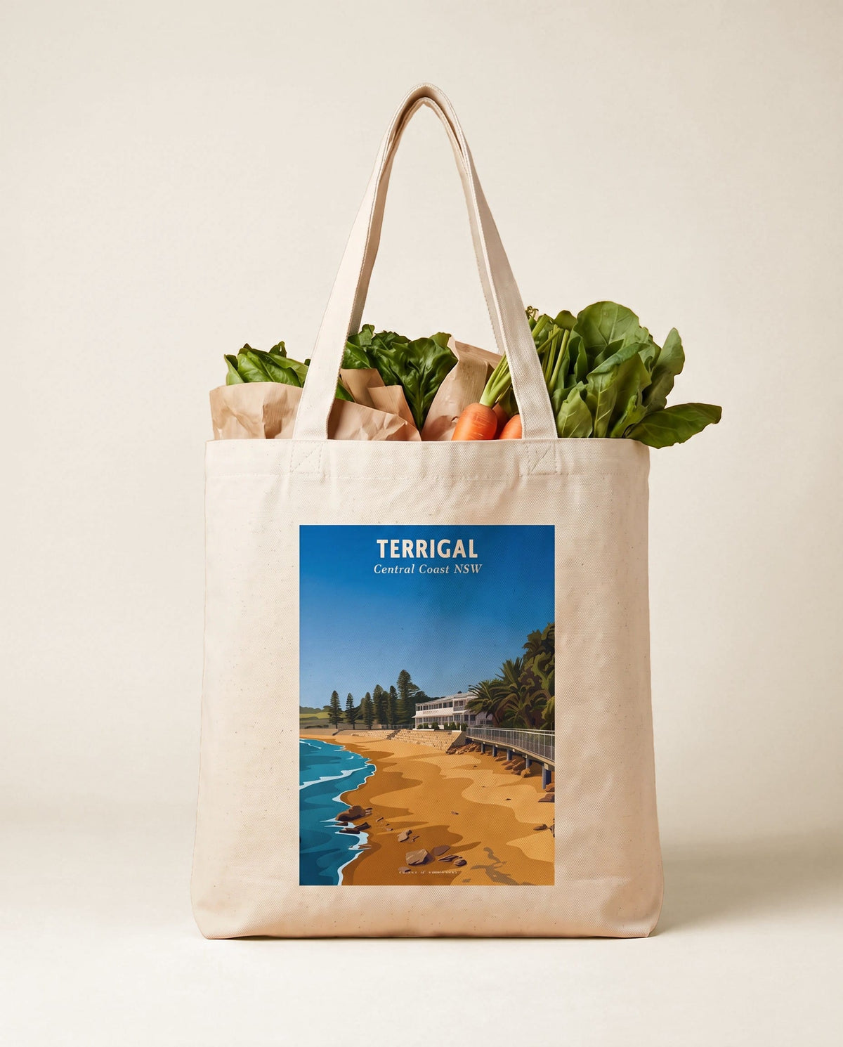 Coast & Compass Terrigal Haven tote bag packed with fresh groceries against a warm sand studio backdrop, cream cotton canvas printed with the Terrigal Haven Central Coast NSW poster design