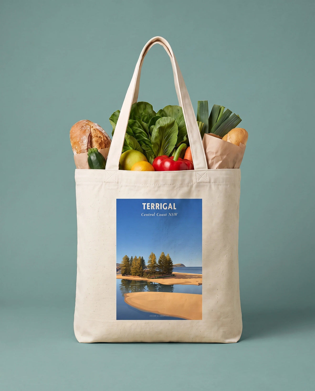 Coast & Compass Terrigal Pines tote bag packed with fresh groceries against a sage studio backdrop, cream cotton canvas printed with the Terrigal Pines Central Coast NSW poster design